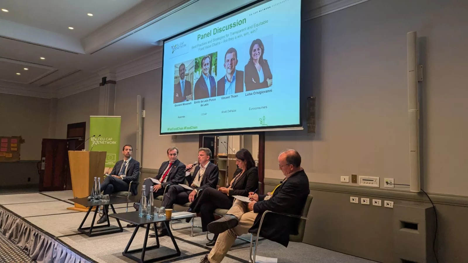 People on stage discussing supply chain during a forum