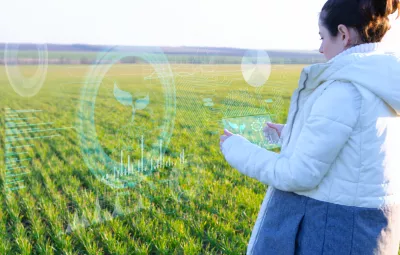 A woman in a field with a tablet and surrounded by pictures representing technology