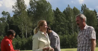 A group of people disussing in a field