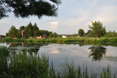 A lake in Latvia surrounded by trees and small houses