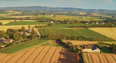 Field with houses and a blue sky