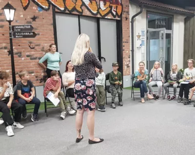 A woman stands in the middle of a group of people during a workshop