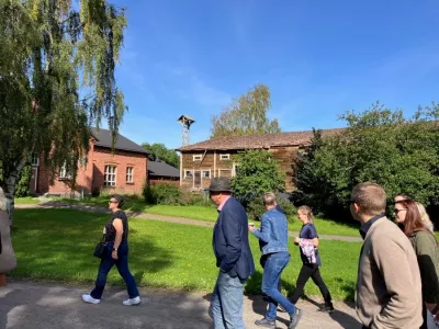 A group of people talking and walking together during the visit to the Mustiala farm