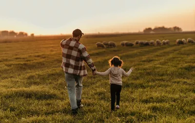 Farmer and his little girl enjoying the tranquility of their rural land at dusk