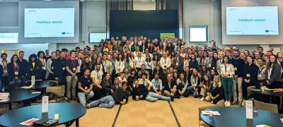 Large group of people posing together indoors in a conference room