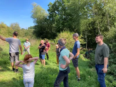 A group of people standing in a grassy area.