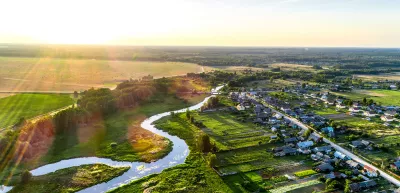 Aerial view. Small european rural village. Blue winding river.