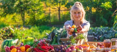 A woman farmer sells fruits and vegetables at a farmers market