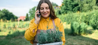 young farmer holding crops while talking on the phone