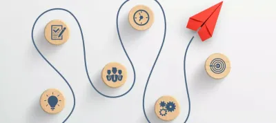 red paper plane and wooden cubes with strategy icons