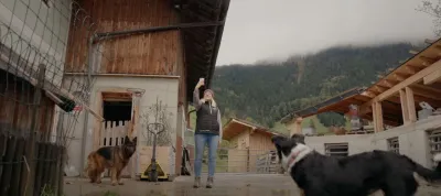 Woman taking selfie on a farm with two dogs