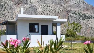 A white house close to a rocky mountain