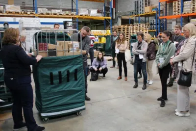 A group of people listening a person into a warehouse