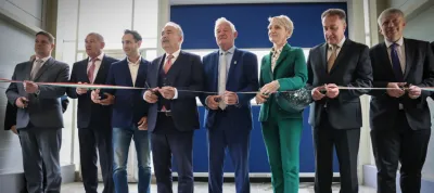 A group of well-dressed people cutting a ribbon