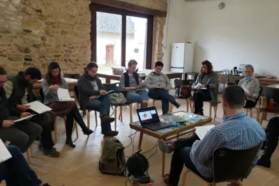 Group of people sitting in chairs and writing