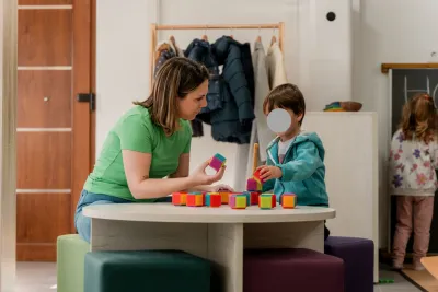 A woman and a small child playing with cubes