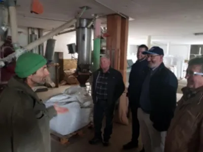 A group of people talking in front of machinery