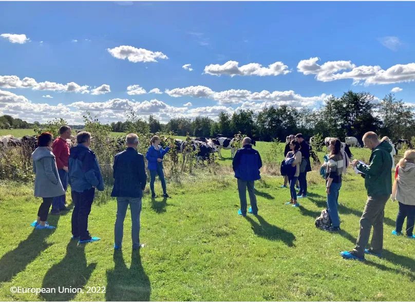 A group of people standing in a field as part of the National Rural Networks and green architecture