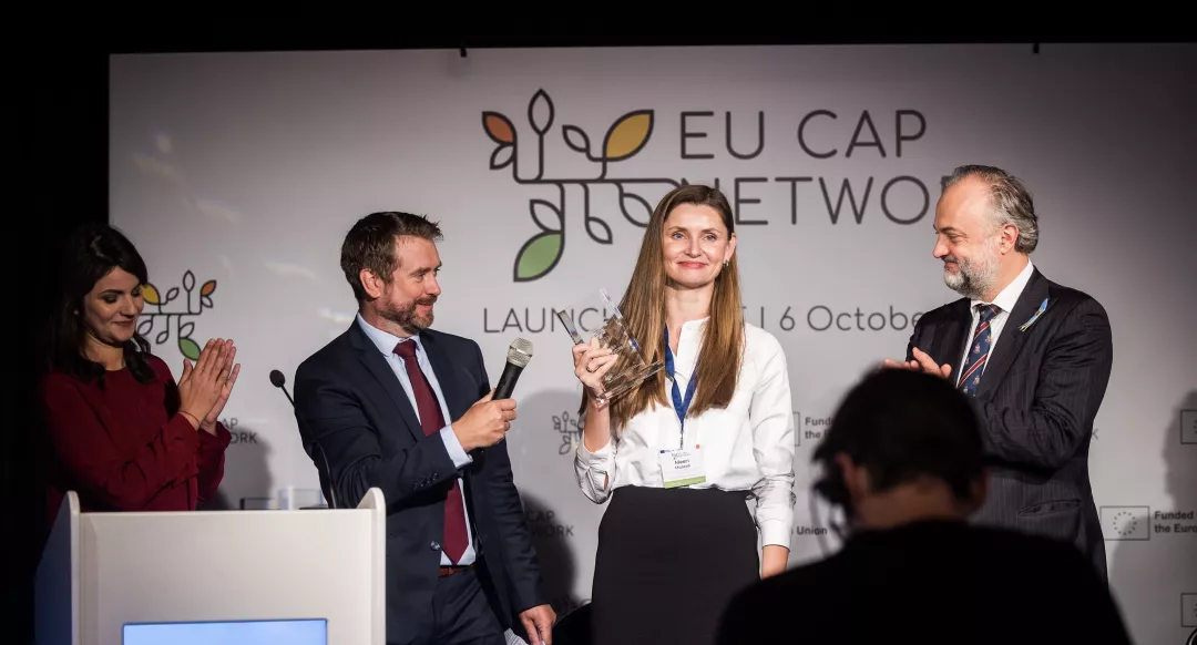 A winner from the Rural Inspiration Awards 2022 edition on stage holding her award