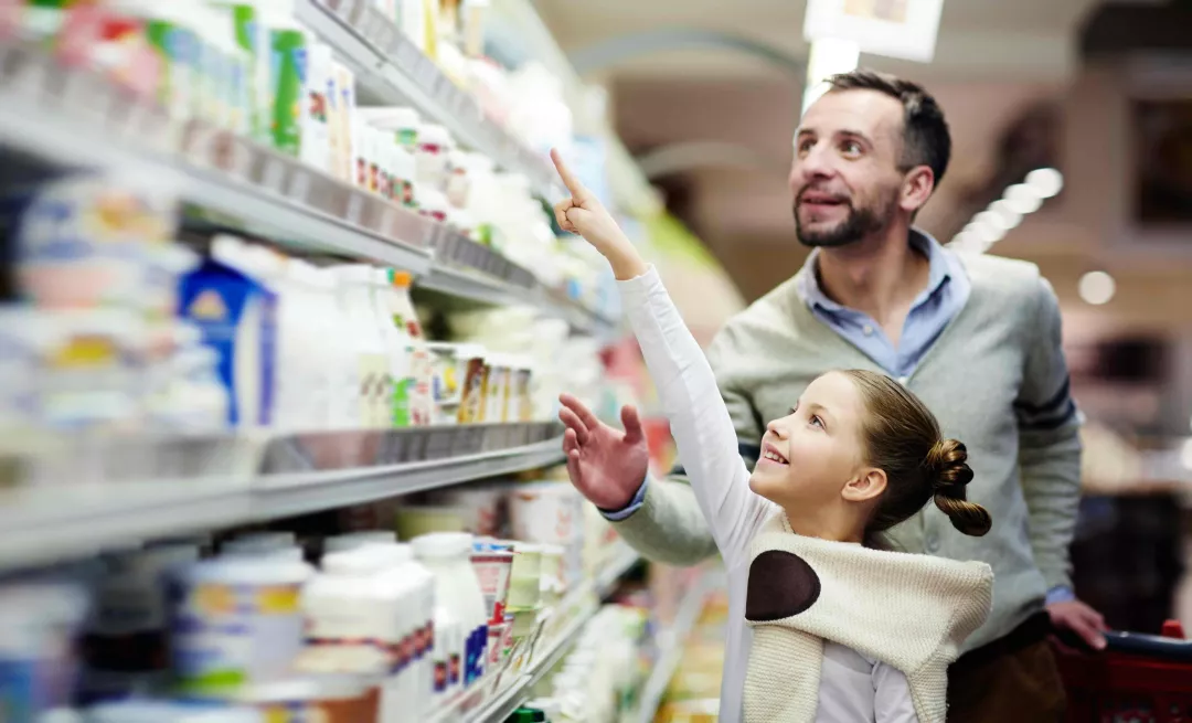 father and daughter look at products in a supermarket aisle