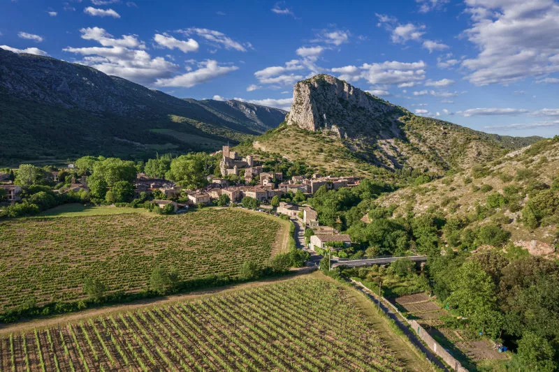 Aerial view of a medieval village, Saint-Jean-de-Bueges with vineyard on mountains in summer in France