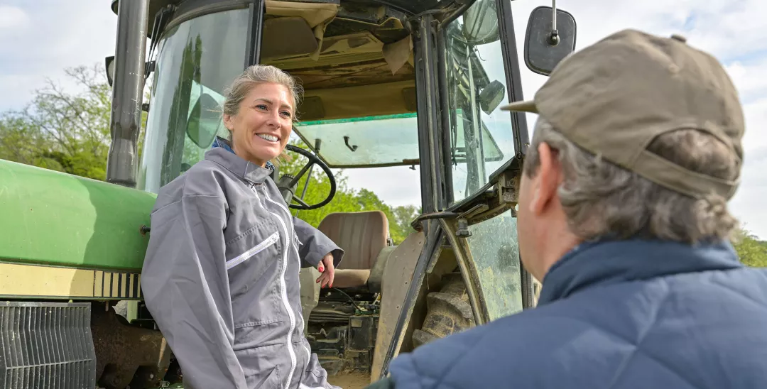 Woman farmer listening the instruction from her boss before to leave the farm with her tractor
