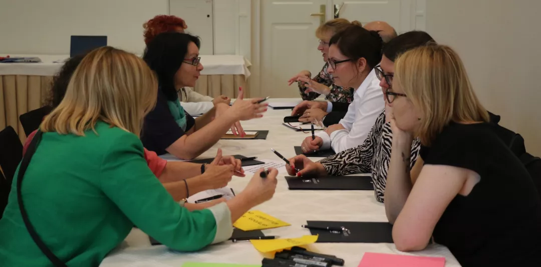 A group of stakeholders discussing around a table.