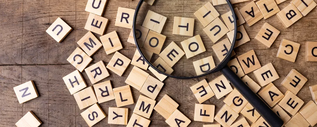 Magnifying glass with many wood letters