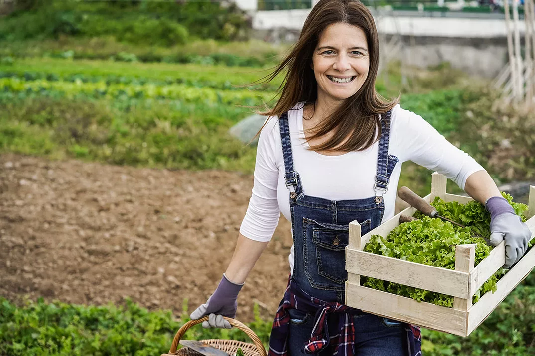 a woman holding a basket of vegetables