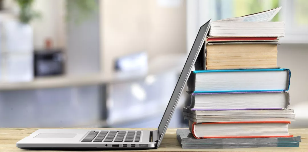 A laptop and books to read EU CAP Network web articles