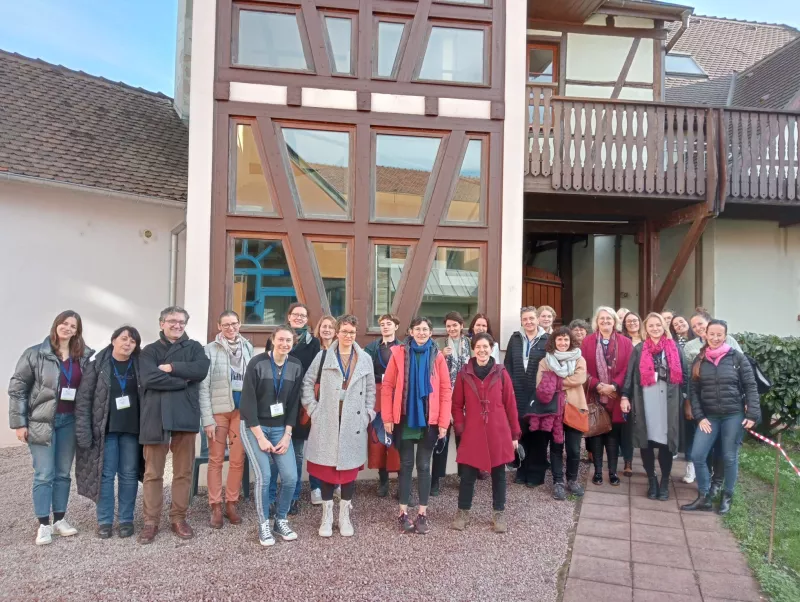 A group of people standing in front of a small building