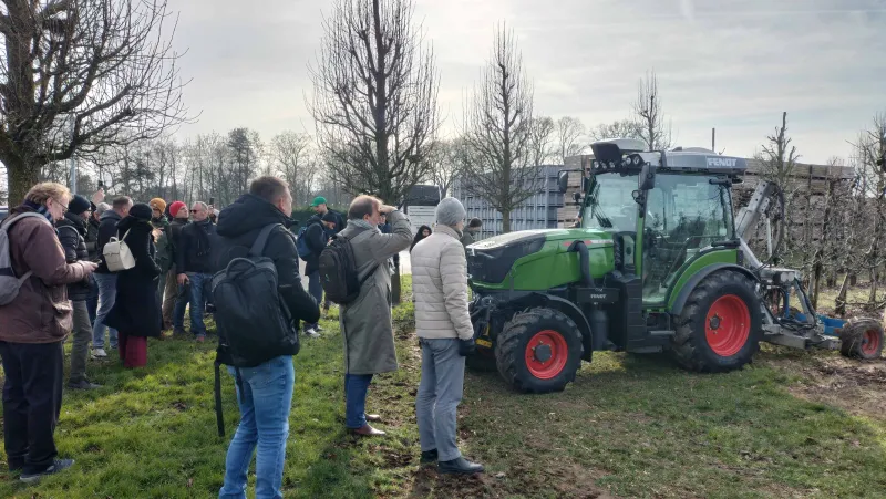 People in orchard with tractor