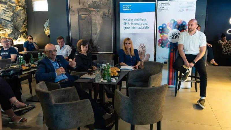Attendees at tables in a restaurant, participating in discussion at the "TERACafé" conference