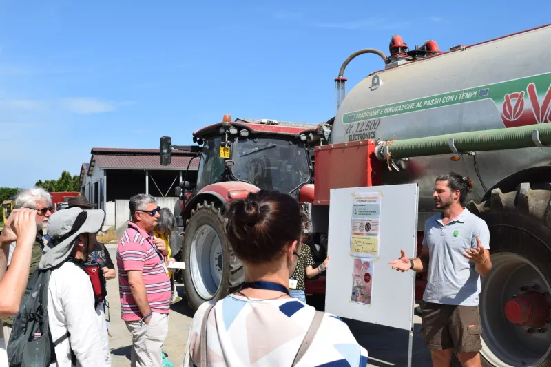 Farmer presenting project to group with tractor