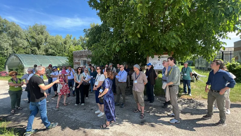 Group outdoors listening to presenting farmer