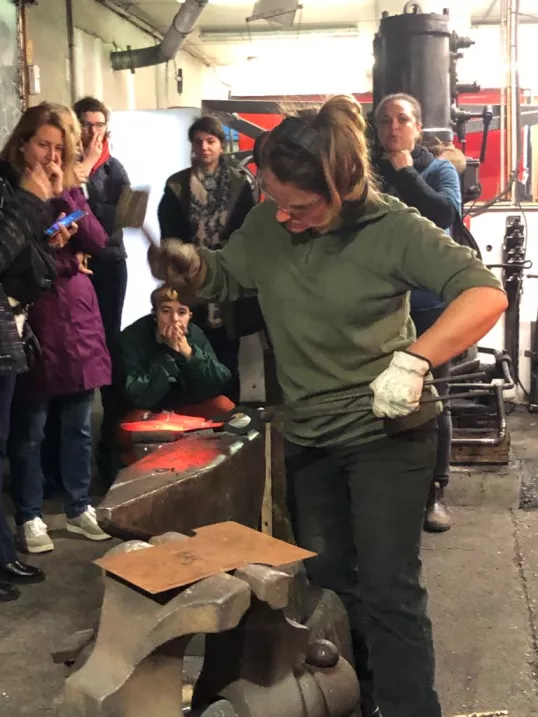 a woman standing next to a pile of metal