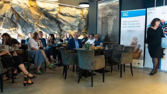 A woman speaks to an audience during the "TERACafé" conference