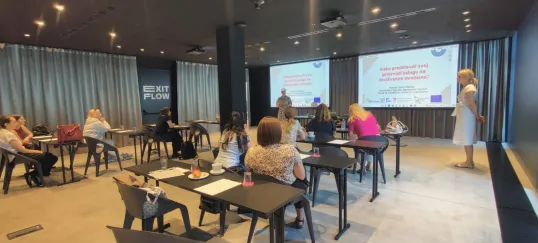 A group sits and watches a presentation about digital marketing