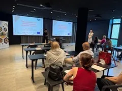 A group sits and watches a presentation about preserving your mental health