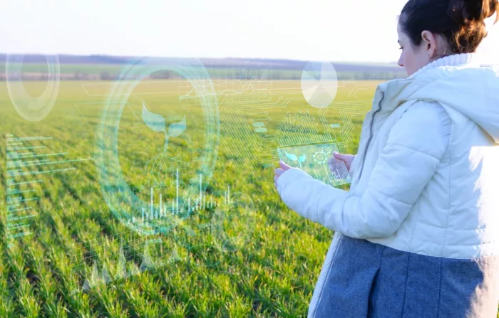 A woman looking at her tablet in a field